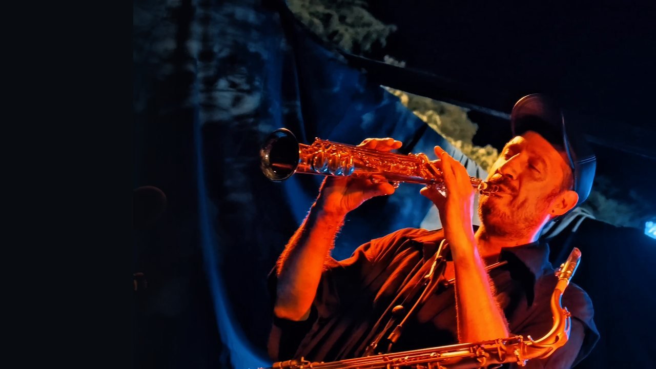 Ash Belgeri au saxophone soprano, lumière cuivre et bleue