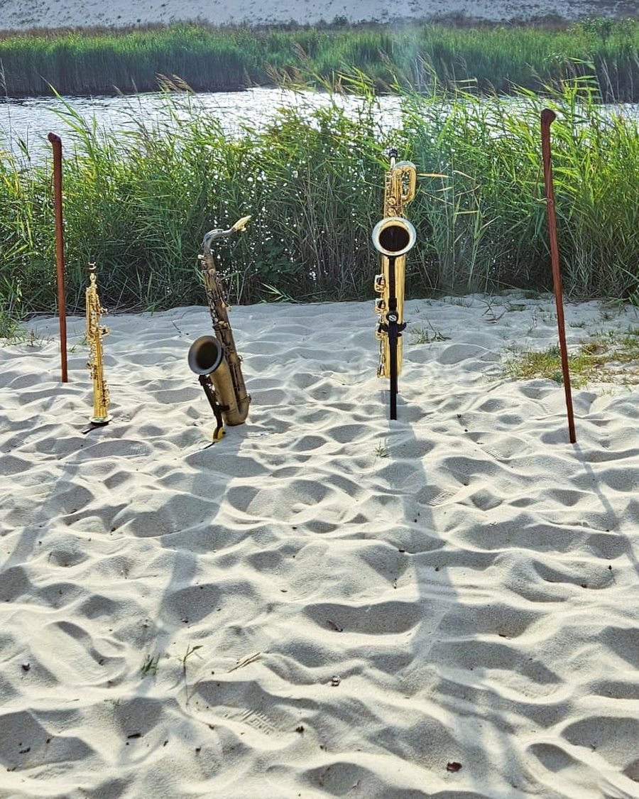 Les trois saxophones d'HARMATTAN — baryton, ténor et soprano — sur leurs stands dans les dunes